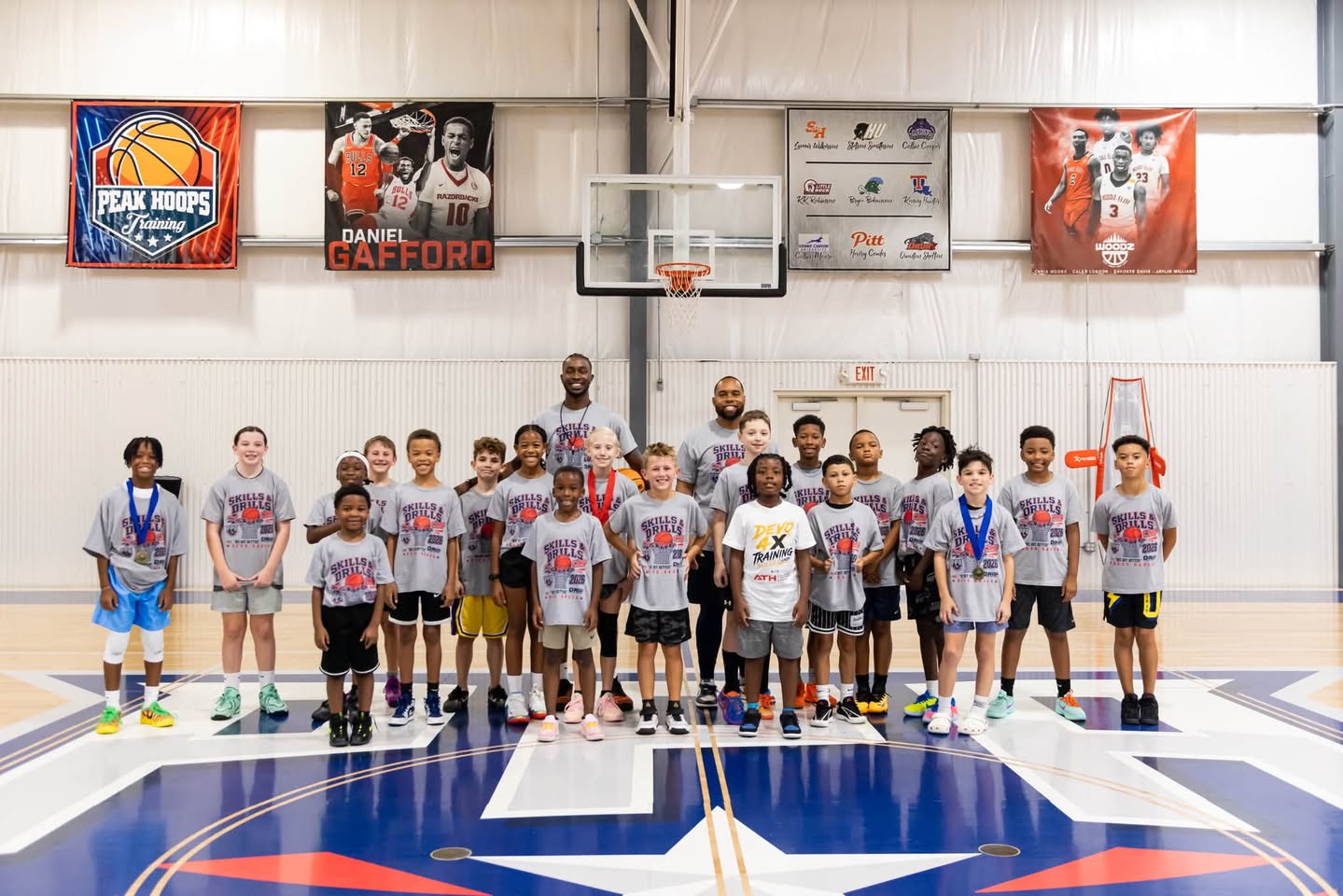 Young basketball players and coaches together on the Peak Performance Academy court